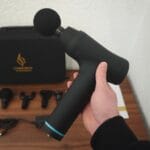 Jeg holder Comforth Muscleflow massagepistol i hånden