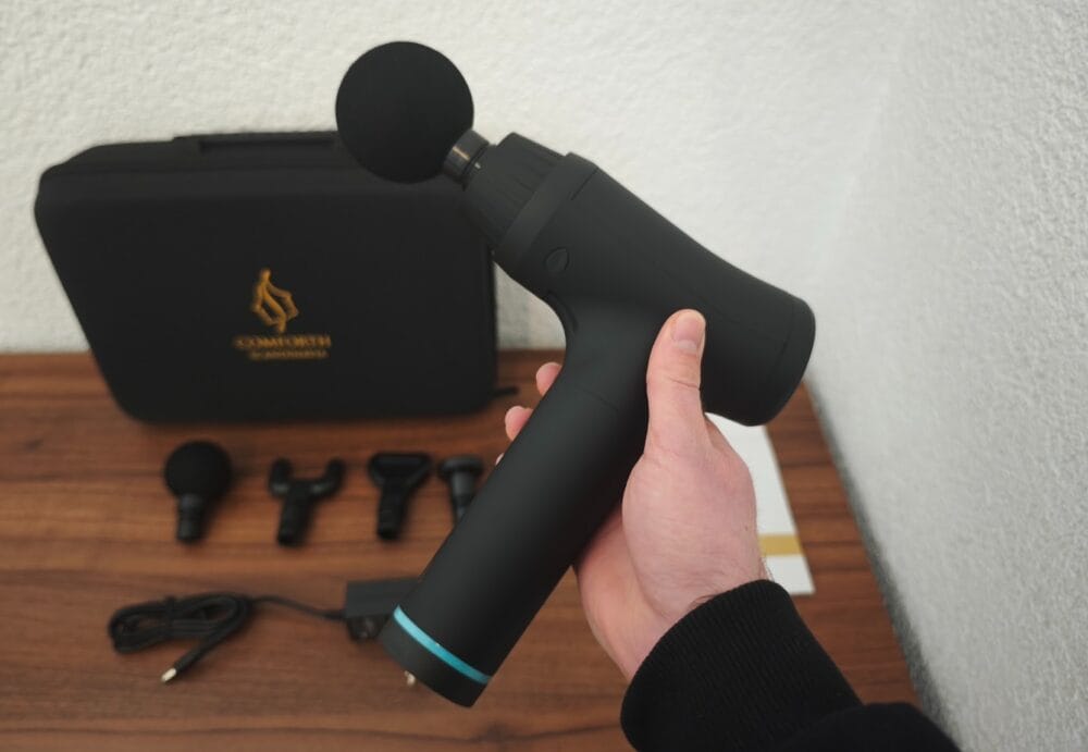Jeg holder Comforth Muscleflow massagepistol i hånden